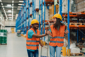 Warehouse workers having fun pushing empty cart in a warehouse