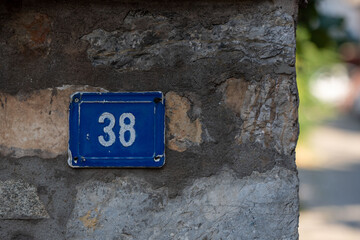 Number 38 in Blue: White Numerals on Metal Plate Around the Blurry Corner.
