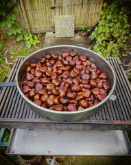 Popular autumn delicacy, baked chestnuts on the hot charcoal in the pan