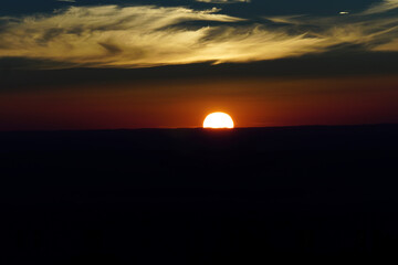 Ein Sonnenuntergang am Horizont mit Wolkenspiel und Abendrot