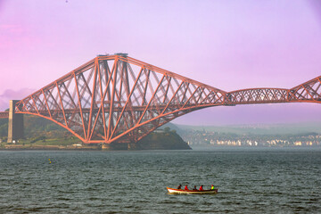 Rowers ply the Firth of Forth under the iconic Forth Bridge