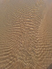water creates beautiful patterns in the sand at Rodiles Beach, Asturias

