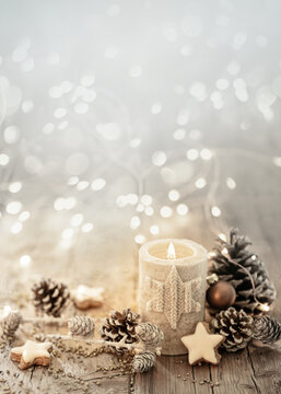 White Christmas candle on rustic wooden boards - Decoration with natural elements, twigs, pine cones and cookies - Advent background with copy space