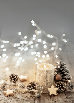 White Christmas candle on rustic wooden boards - Decoration with natural elements, twigs, pine cones and cookies - Advent background with copy space