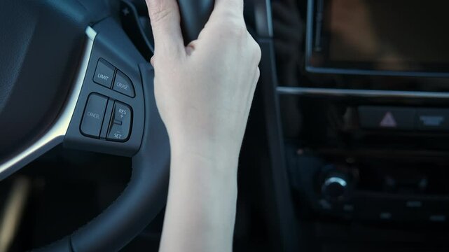 Driver girl turns button on wheel. A view of driver finger press the car buttons on the wheel during driving time.