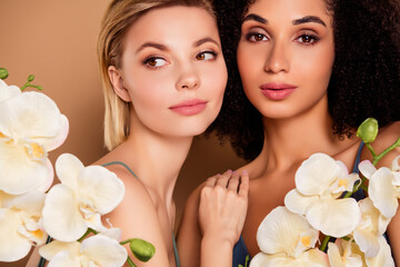 Photo of seductive cute women nude shouldrs enjoying orchids aroma isolated brown color background