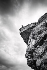 Monochrome Rocky Cliff Against Dramatic Sky