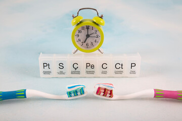 A composition showing daily dental care on a white background. Toothbrushes, clock and weekly chart