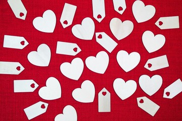 Wooden hearts and decorative heart label blank tags display against a red stitch background