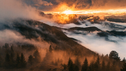 Sunset in the Mountains of Austria with fog filmed with a drone