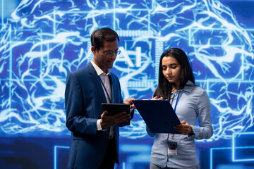 IT department coworkers solving tasks on laptop and tablet, running artificial intelligence...