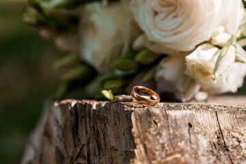 Romantic Wedding Rings on a Rustic Wooden Surface with Delicate Flowers in the Background