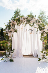 Elegant Floral Wedding Arch with Drapery and Initials