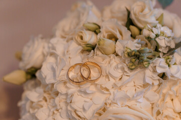 Elegant Wedding Rings Nestled in a Bouquet of White Roses