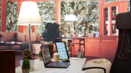 Empty modern home workstation of an entrepreneur with laptop and tablet, financial analytics data studied for startup investment and development. Remote job in business industry.