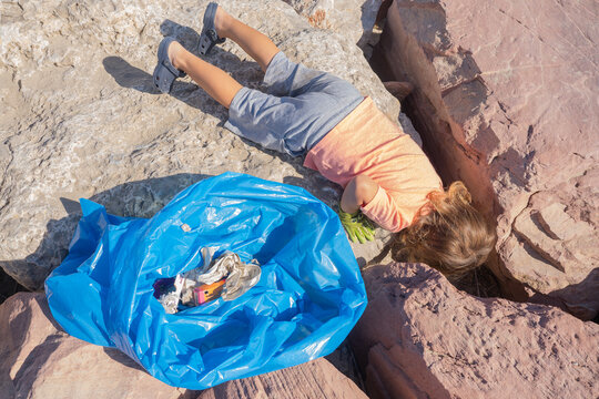 Young volunteer cleaning marine environment from trash