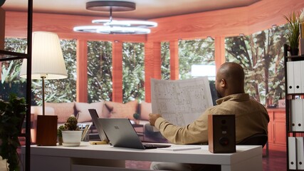 Business owner using digital tools to review and evaluate office spaces blueprints, focusing on leasing a functional and creative workspace. Searches for real estate, strategy planning. Camera B.