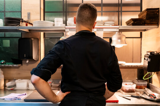 Professional chef working diligently in busy restaurant kitchen