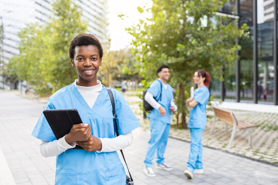 Young nurse students with digital devices outdoors