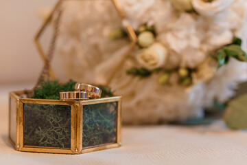 Elegant Wedding Rings Displayed in a Stylish Decorative Box with Floral Arrangement Background
