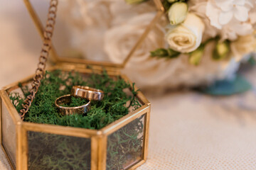Elegant Wedding Rings Displayed in Glass Box with Floral Arrangement