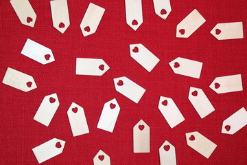 Wooden love heart tag blanks against a bright red stitch background