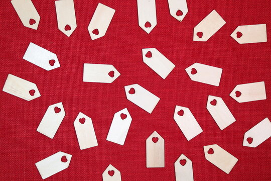 Wooden love heart tag blanks against a bright red stitch background