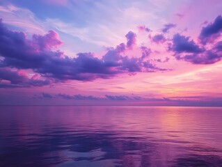 Obraz premium Purple and pink clouds during a serene evening sky over calm waters