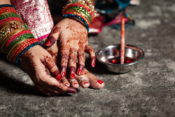 A traditional Indian woman is wearing a silver toe ring on her toe.