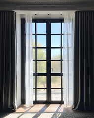 Fototapeta premium Window with curtains and blue sky in the background. Interior design.