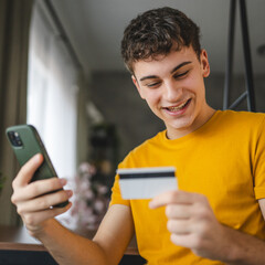 Adult young man buy online on mobile phone and use credit card