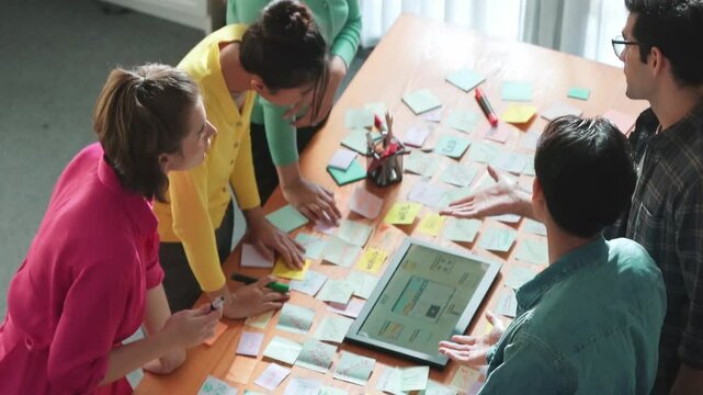 Top view of skilled programmer brainstorming idea about mobile phone interface while develop app development by using wireframe prototype. Web designer planning at table with sticky notes. Symposium.