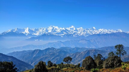 Mountain range with snow-capped peaks under a clear blue sky, highlighting natural beauty and majesty