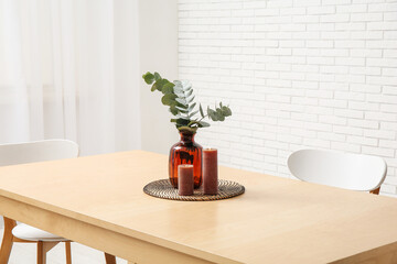 Table with eucalyptus branches in vase and candles in stylish dining room