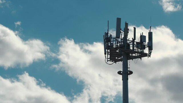 5g mobile network communication tower with cellular antenna transmitter and receiver, broadcasting 4g lte equipment, phone network station on sky with clouds background 4k