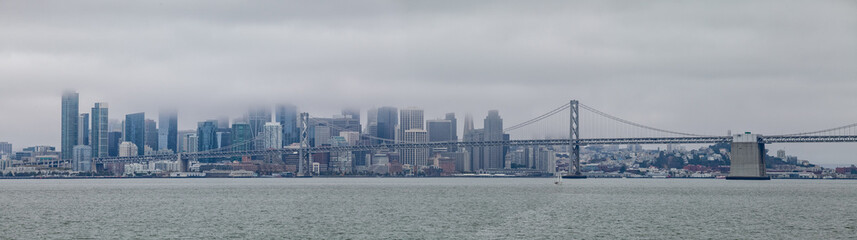 Fototapeta premium Pano of San Francisco Skyline with Bay Bridge on a Cloudy Day
