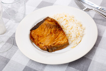 Image of tasty grilled tuna fillet with rice in interior of cafe
