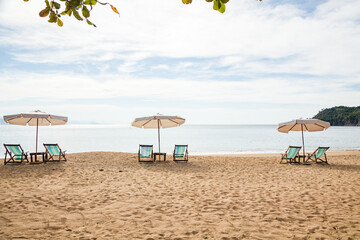 Beautiful panoramic view of Jabaquara beach in Ilhabela with chairs and umbrella on tropical island on the Brazilian sea coast during a sunny day of vacation and sightseeing trip.