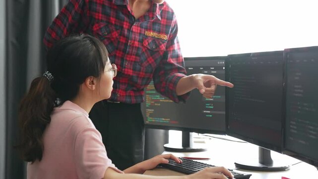 Slow motion back end or software developer manager supervising his team on new application program development on debugging and solving complex code algorithms on monitor. Burgeoning