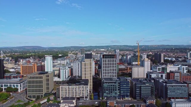 Aerial drone footage of Cardiff city centre as seen from Atlantic Wharf and Butetown neighbourhoods with modern apartment and office blocks in the foreground. Diagonal rise shot.