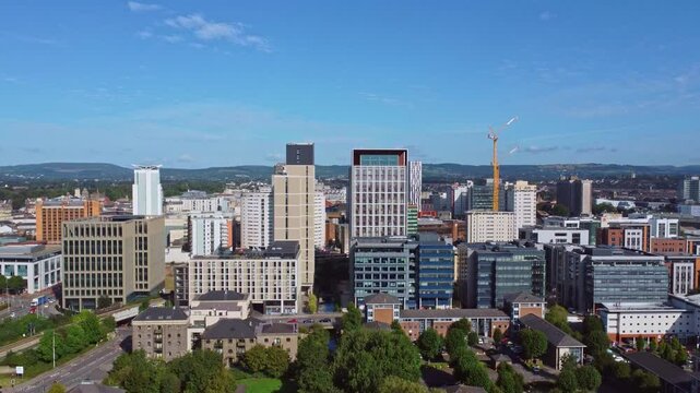 Aerial drone footage of Cardiff city centre as seen from Atlantic Wharf and Butetown neighbourhoods with modern apartment and office blocks in the foreground. Pedestal up shot.