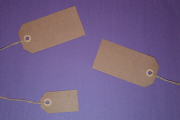 Blank brown paper tags set at an angle against a purple background