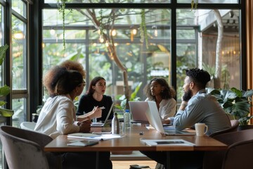Diverse Business Team Meeting Around a Table with Laptops and a Water Bottle
