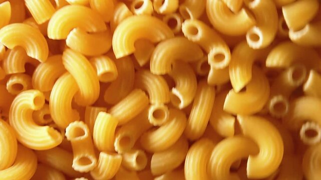 Uncooked Chifferi Rigati Pasta - Top View, Low Key Light. Fat and Unhealthy Food. Classic Dry Macaroni, Rotating Background. Italian Culture and Cuisine. Raw Golden Pasta Texture - Side Rotation Left