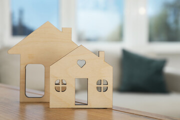 Models of houses on wooden table indoors, closeup