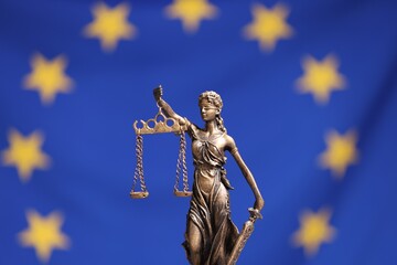Fototapeta premium Figure of Lady Justice against European Union flag, closeup