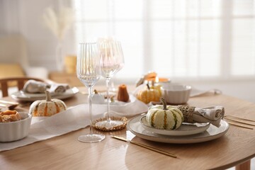 Stylish table setting with beautiful dishware and autumn decor in dining room