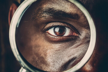 Beautiful detailed macro photography of the eye of a man, woman and children through a magnifying glass as a close or careful focus on the health and optics of vision
