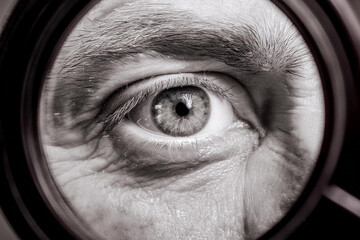Beautiful detailed macro photography of the eye of a man, woman and children through a magnifying glass as a close or careful focus on the health and optics of vision
