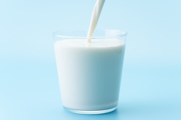 透明なグラスに牛乳を注ぐ